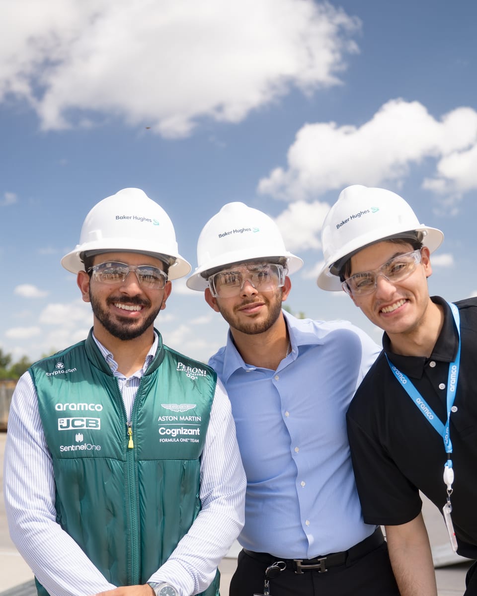 Faris and two fellow interns in hard hats and safety glasses at an industrial field site